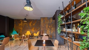 Un comedor moderno con una mesa negra, sillas estampadas y una lámpara colgante.