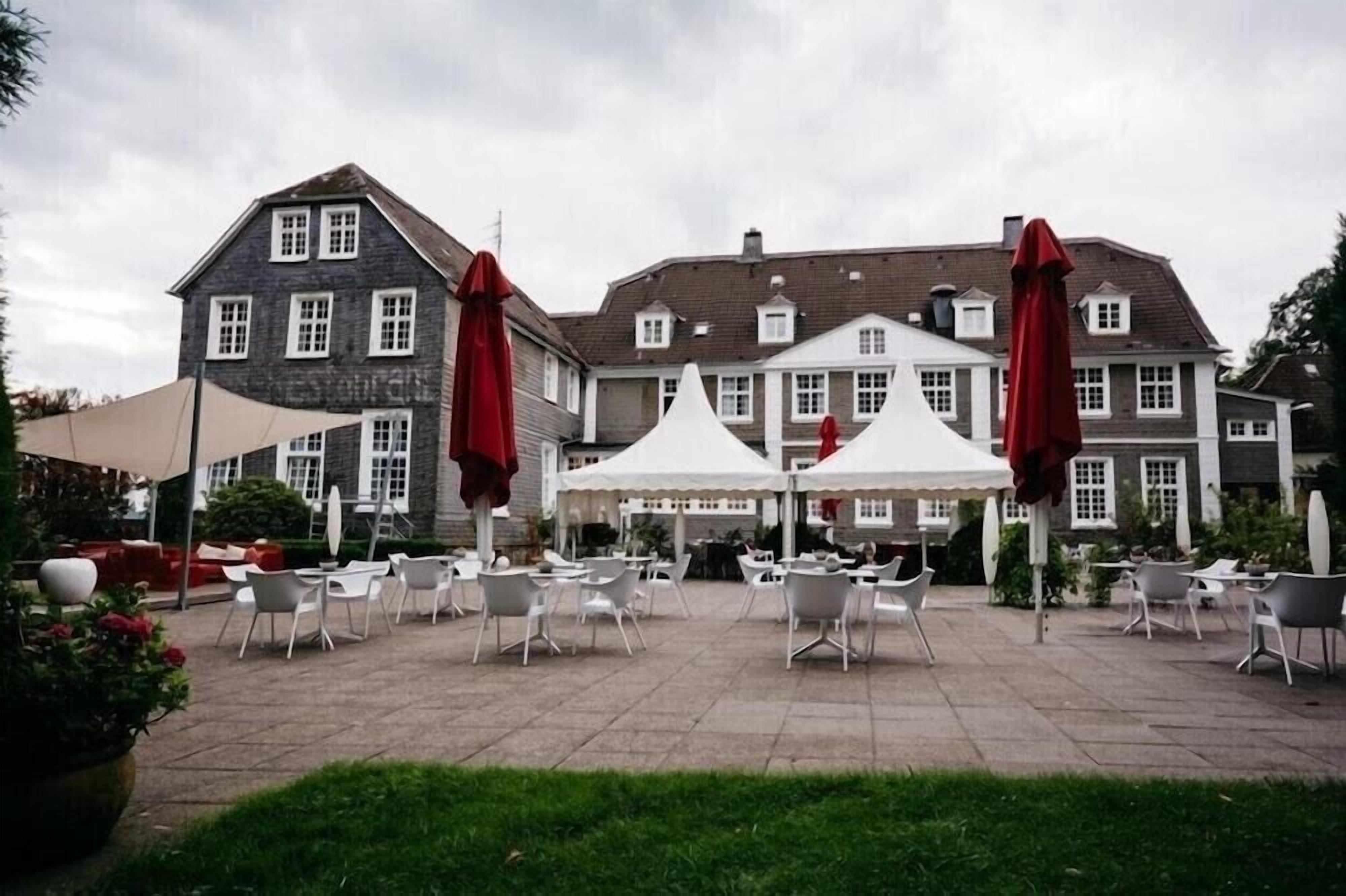 A courtyard with outdoor seating and a large building in the background.
