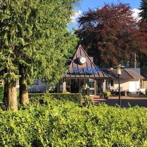 Un hôtel doté d’un toit triangulaire original et d’une horloge.