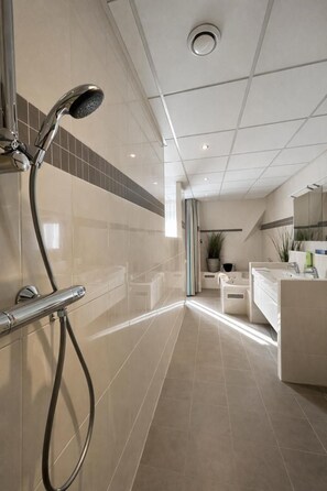 Un baño moderno con ducha, lavabo e inodoro.