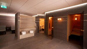 Un moderno vestíbulo de hotel con una recepción, zona de estar y una sala de sauna.