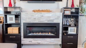 A modern living room with a fireplace, dark wood furniture, and a red rug. - The Jazzy Junction-Great Downtown Location! (Pensacola)