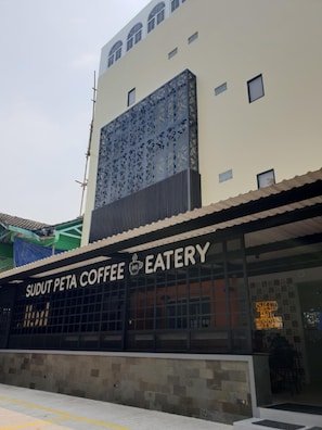 A building with a sign for Sudut Peta Coffee & Eatery. - Sambina Prime Hotel by Danapati (Jakarta)