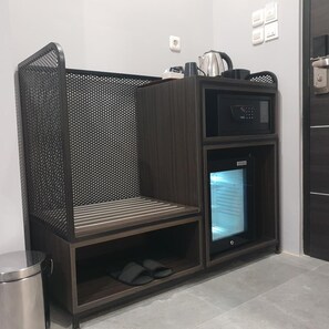 A compact kitchenette with a microwave, a small refrigerator, and a coffee maker on the countertop. - Sambina Prime Hotel by Danapati (Jakarta)