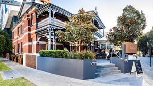 A building with a balcony, a sign for 'Julio's,' and a sidewalk with a planter. - Holiday Inn West Perth (Perth)