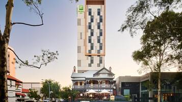 A Holiday Inn hotel with a modern design, a balcony, and a restaurant named 'Jules.'