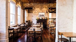 A restaurant with brick walls, wooden tables, and chairs. - Holiday Inn West Perth (Perth)