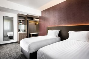 A hotel room with two beds, a wardrobe, a mirror, and a small table with a coffee maker. - Holiday Inn West Perth (Perth)