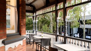 An outdoor dining area with brick walls, white balustrades, and tables and chairs. - Holiday Inn West Perth (Perth)