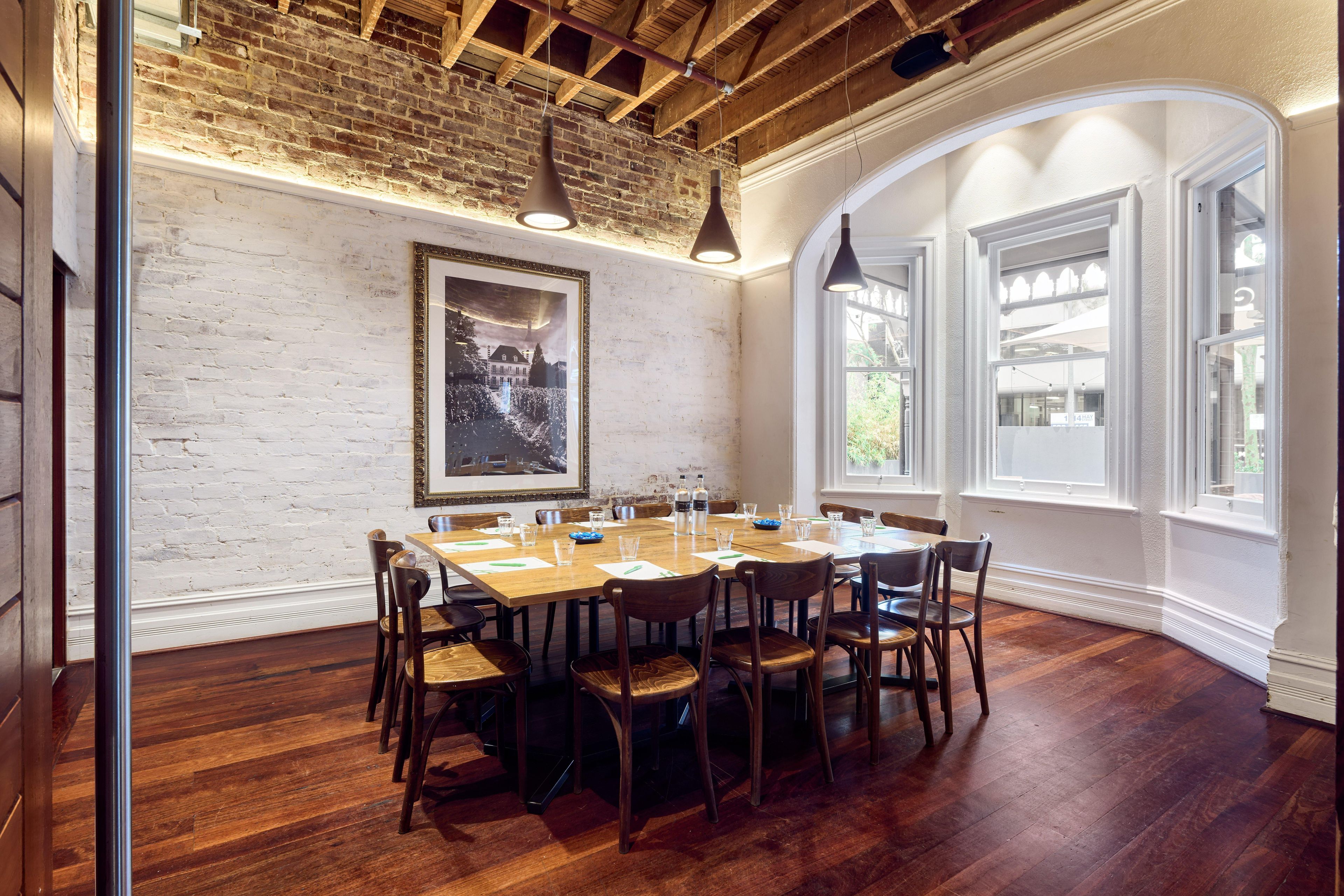 A dining area with a brick wall, wooden ceiling, and large windows.