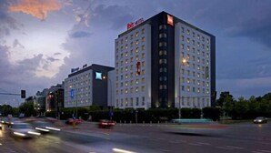Un hotel con varios pisos, un llamativo letrero 'Hilton' y un diseño arquitectónico moderno.