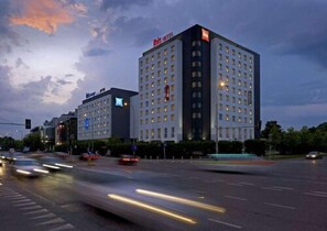 Un hôtel à plusieurs étages, avec une enseigne « Hilton » bien visible et une architecture moderne.