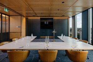 A conference room with a long table, chairs, and a city view. - Voco Auckland City Centre (Auckland)