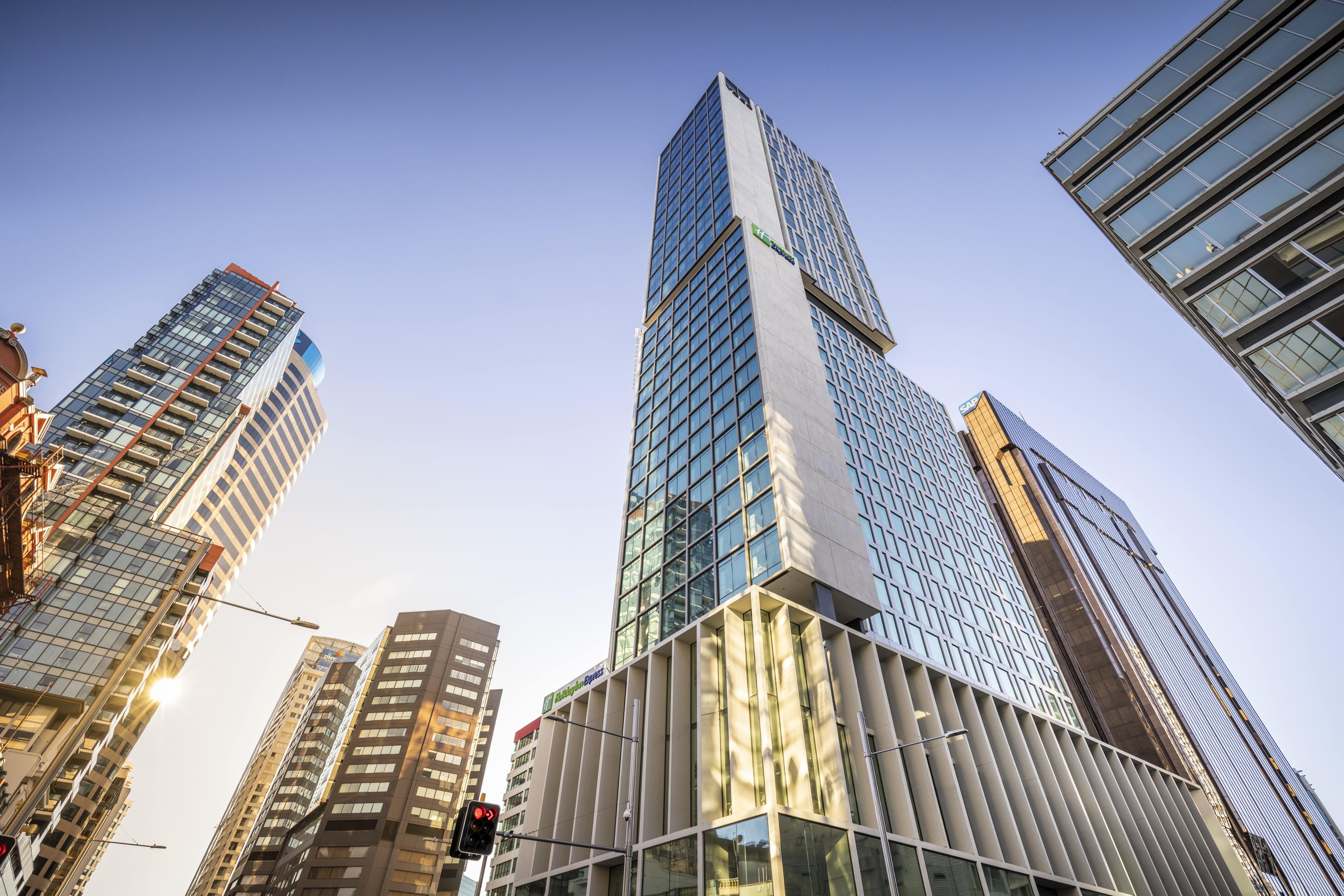 Ein Hochhaus mit moderner Glasfassade, umgeben von weiteren hohen Gebäuden.