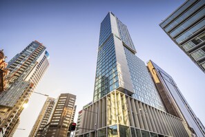 A high-rise building with a modern glass facade, surrounded by other tall buildings. - Voco Auckland City Centre (Auckland)