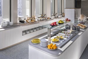 A buffet with various food items, a glass display case, and a tiled backsplash. - Holiday Inn Express Auckland City Centre (Auckland)