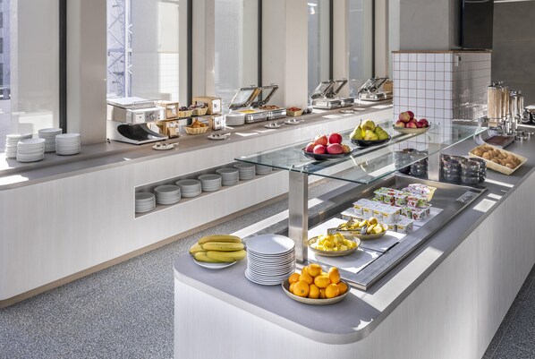 A buffet with various food items, a glass display case, and a tiled backsplash. - Holiday Inn Express Auckland City Centre (Auckland)