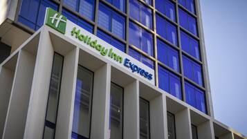 Ein Holiday Inn Express Gebäude mit auffälligem Schild, großen Fenstern und modernem architektonischen Design.