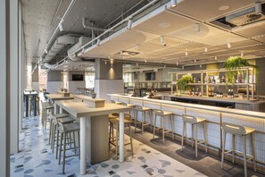 A modern bar area with high stools, a counter with bar stools, and a bar stocked with bottles. - Holiday Inn Express Auckland City Centre (Auckland)