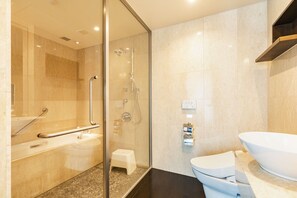 Une salle de bain moderne avec une douche à parois de verre, un lavabo blanc et une grande baignoire blanche.