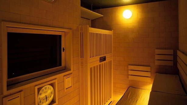 A hotel room with a large window, a clock, a radiator, and a bed. - Dormy Inn Premium Nagasaki Ekimae (Nagasaki)