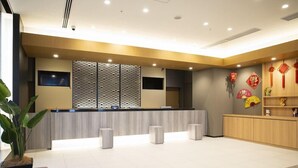 A modern reception area with a reception desk, seating area, and decorative elements. - Dormy Inn Premium Nagasaki Ekimae (Nagasaki)
