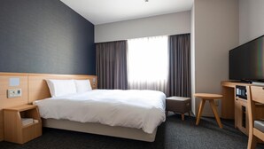A hotel room with a large bed, a desk with a chair, a television, and a window with curtains. - Dormy Inn Premium Nagasaki Ekimae (Nagasaki)