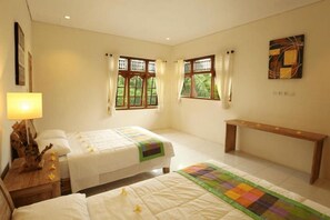 A hotel room with two beds, a bench, and a window with curtains. - Bali Sunshine Homestay Ubud by Zuzu (Sukawati)