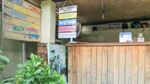 A wooden reception desk with a sign indicating 'Bali Sunshine Home Stay' and various transportation options. - Bali Sunshine Homestay Ubud by Zuzu (Sukawati)