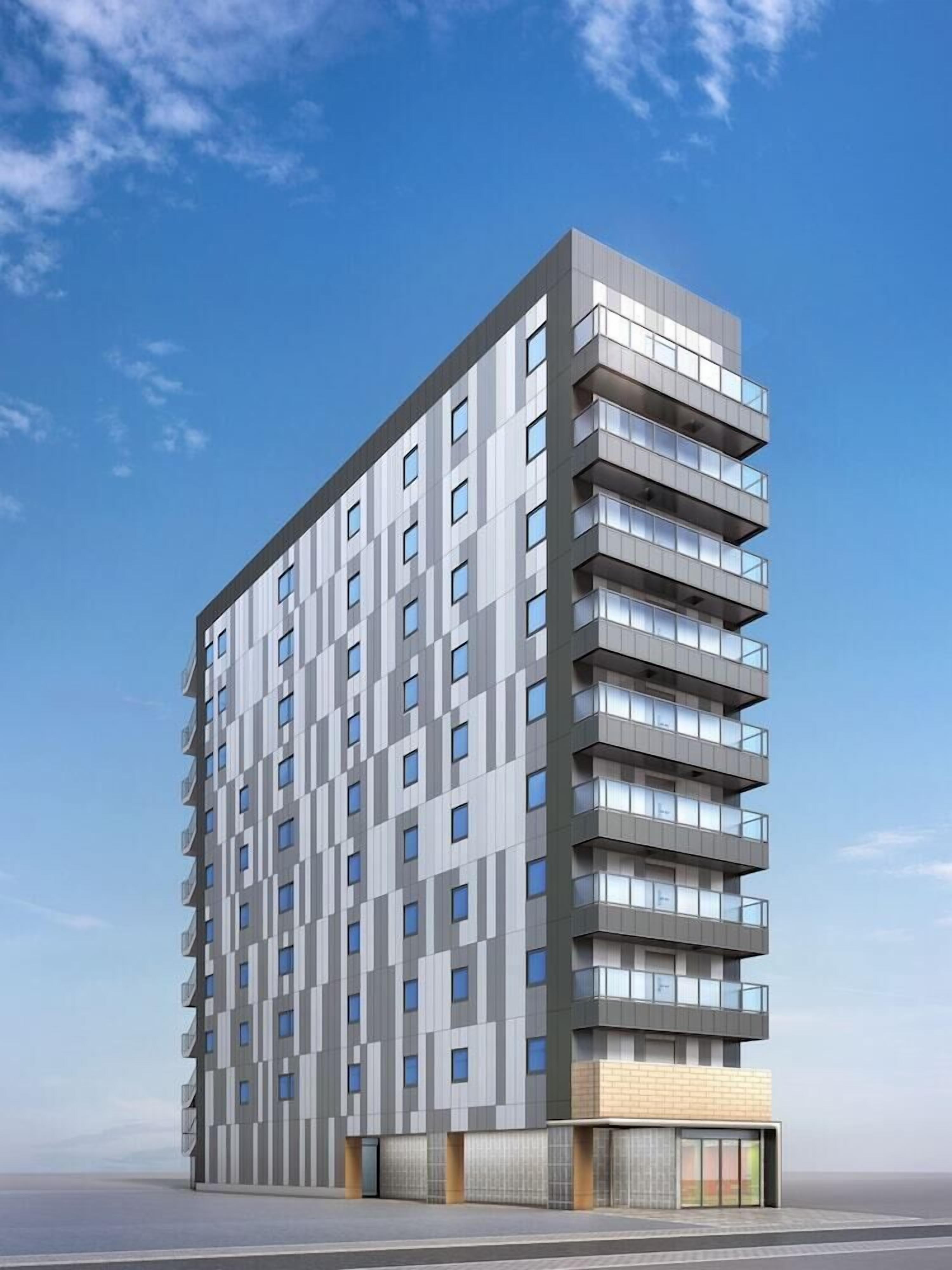 A modern multi-story building with a grid-like facade, numerous windows, and balconies.