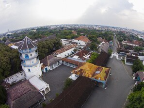 Vista aérea de un pueblo con una torre destacada, calles estrechas y una combinación de edificios residenciales y comerciales.