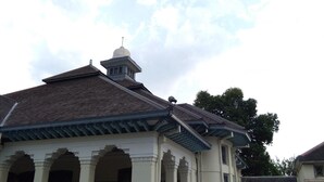 Un bâtiment doté d’un toit en pente, d’une petite tour surmontée d’une croix et d’une série d’arches.