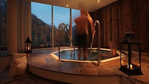 A spa area with a hot tub, stone flooring, and a view of the outdoors. - Hotel Union Geiranger (Stranda)
