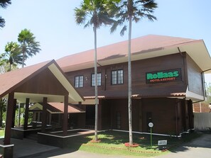 Un edificio de dos pisos con un letrero que dice "Rolla's Hotel & Resort".