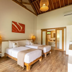 Quarto com duas camas, teto de madeira, luminária pendente e um quadro na parede.