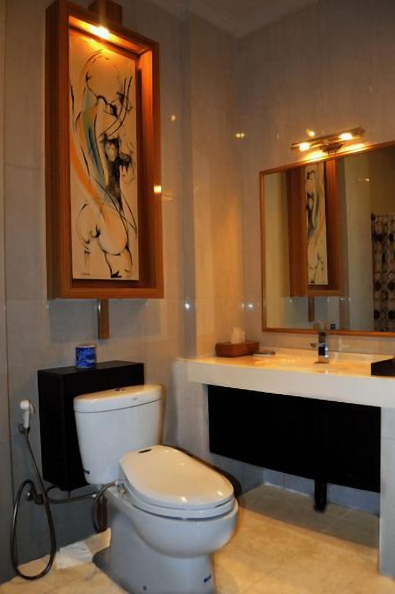 A bathroom with a toilet, a sink, and a mirror.