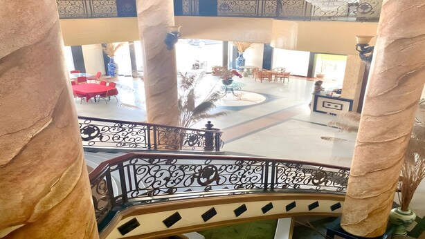 A spacious lobby with a central fountain, multiple seating areas, and a grand staircase. - Hotel Prima Indah (Sibolga)