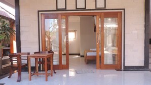 A room with a bed, a table, and chairs. There are framed pictures on the wall. - Pakels Bali Villas (Karangasem)