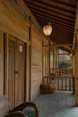 A wooden interior with a wooden ceiling, a wooden bench, and a wooden railing. - Umadhatu Village & Outbound Resort (Selemadeg)