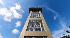 Un immeuble imposant, doté d’une architecture moderne, avec de grandes fenêtres et un ciel dégagé en arrière-plan.