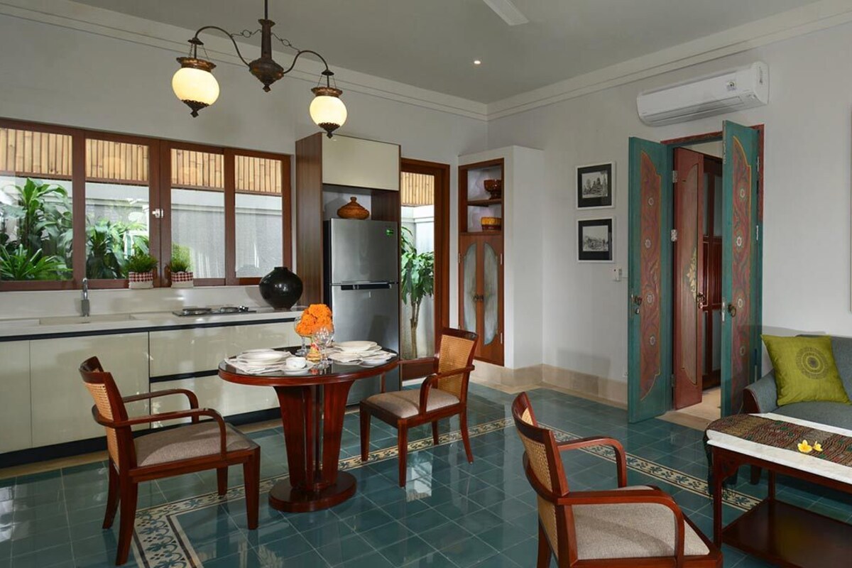 A dining area with a round table, chairs, and a decorative centerpiece.