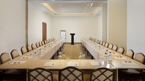 A conference room with a long table, chairs, water bottles, and a podium. - Hotel ZIA Bali - Kuta (Kuta)