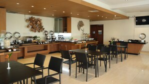 A modern restaurant with a long counter, black chairs, and a wooden ceiling. - Hotel ZIA Bali - Kuta (Kuta)