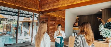 Un interior moderno con piscina, ventanas amplias y mostrador de recepción.