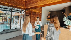A modern interior with a pool, large windows, and a reception desk. - Amolas Canggu Villa Balinese Muralism (Canggu)