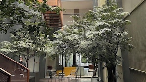 An indoor atrium with a glass ceiling, modern furniture, and potted plants. - Fulmar Pasteur (Bandung)
