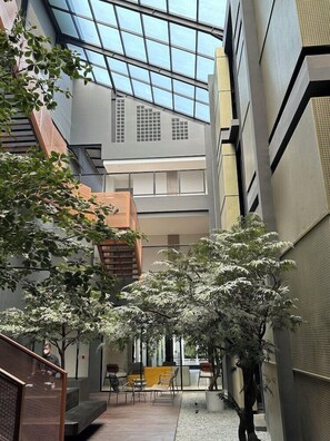 Un atrio interior con techo de cristal, muebles modernos y plantas en macetas.
