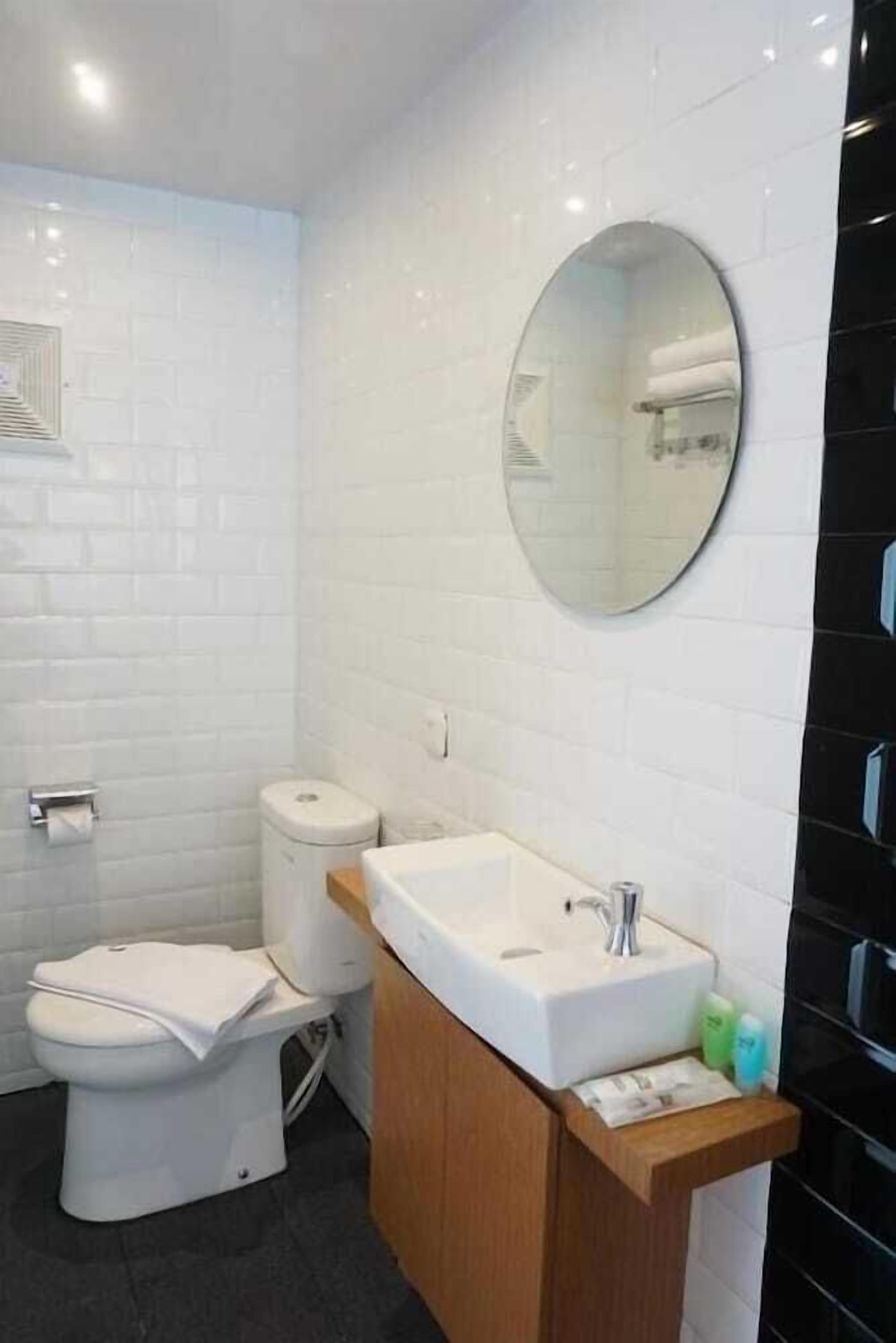 Une salle de bain moderne avec des toilettes, un lavabo et un miroir.