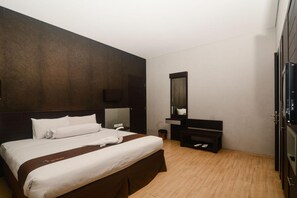 A hotel room with a large bed, a TV, a mirror, and a wardrobe. - Batu Suki Resort and Hotel (Batu)