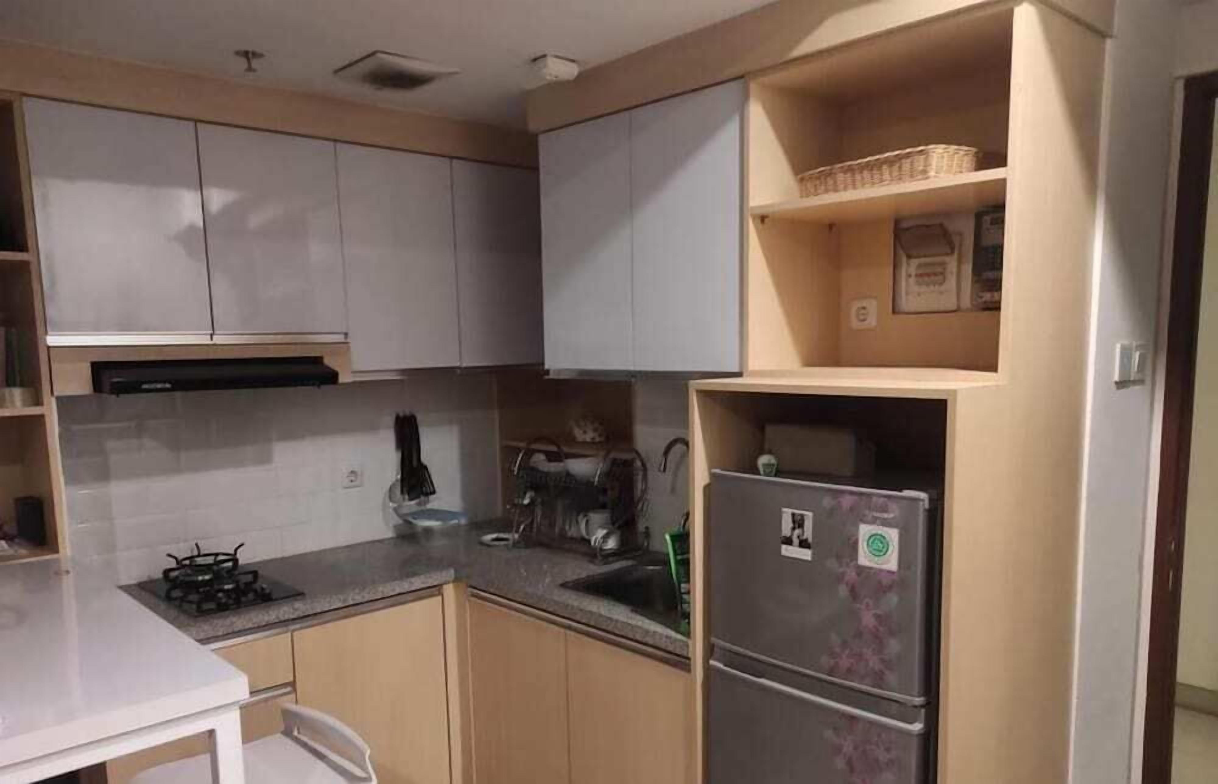 Cocina compacta con estufa a gas, fregadero y refrigerador.